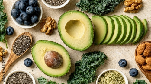 A vibrant flat lay of healthy foods like avocado, blueberries, nuts, and greens