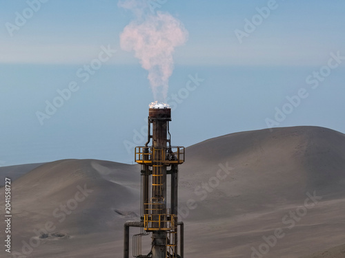 Cuadro en lienzo Industrial refinery flare burning gas over coastal desert dunes