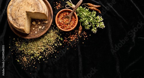 Flat lay of Provoleta ingredients on black velvet, copy space
