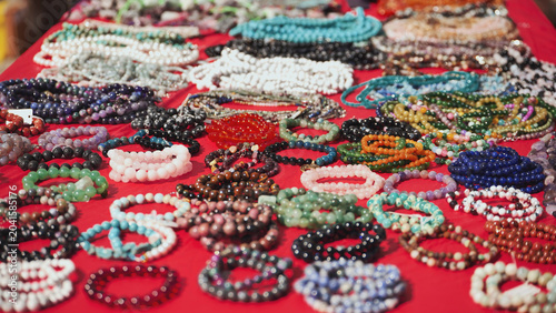 Colorful bracelets and necklaces resting on red cloth in India
