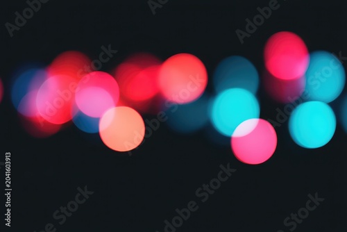 Colorful bokeh lights in vibrant red, blue, and pink tones creating a festive atmosphere.
