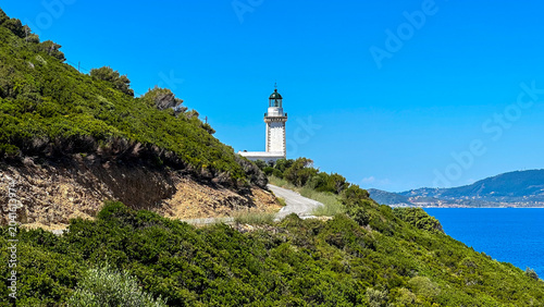 Bild auf Leinwand Historic lighthouse on the southern coast of Skopelos Island, Greece, overlooking the Aegean Sea under a clear summer sky