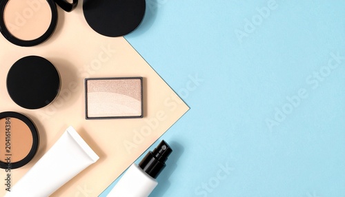 Cosmetic product flatlay with powders, bottles, and divided background