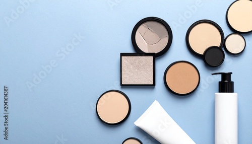 Cosmetic product flatlay with powders, bottles, and divided background