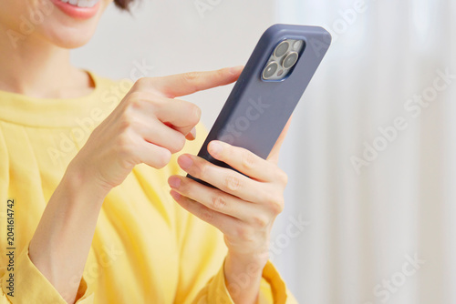 リビングでスマホを使う女性　顔無し