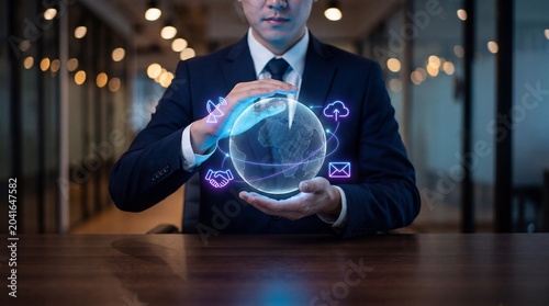 Businessman holding a digital globe with global business communication icons in a modern office environment