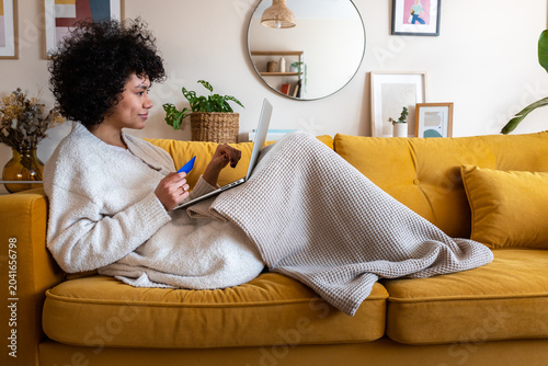 Canvas Print Woman shopping online with credit card on sofa