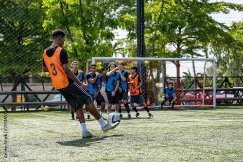Obraz na plátně African American soccer player taking free kick shot during football match
