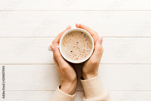 Fotografie Minimalistic style woman hand holding a cup of coffee on Colored background