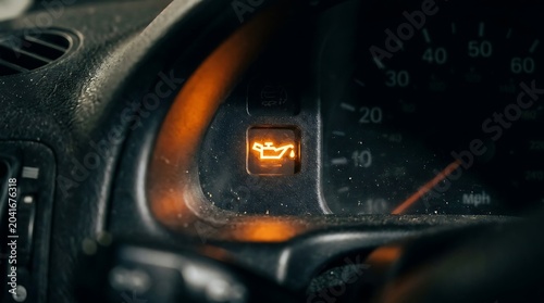 Illuminated Oil Warning Light Glowing on Dark Car Dashboard