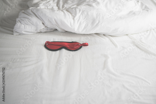 Eye mask in rumpled bed