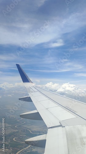View from an airplane window showing the wing over a scenic landscape