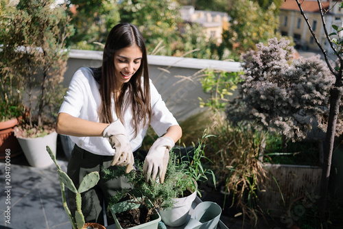 Young Woman Tending Plants on Urban Rooftop Garden – Sustainable Green Living Lifestyle