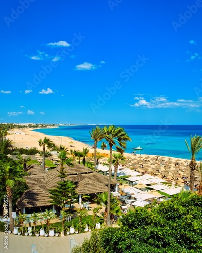 Hammamet, Tunisia - MAY 16, 2025: Beach of Hammamet, the first tourist destination in Tunisia. Located on the Gulf of Hammamet. Beach and boats on shallow water, view on Mediterranean sea. Crystal-cle