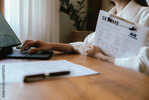 A professional holding a resume in a modern office workspace, representing job applications, recruitment, talent acquisition, career development, and human resources management.