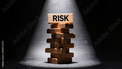 Wooden Risk Block on Unstable Tower Under Spotlight
