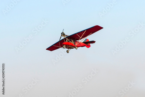 Old classic propeller airplane flying on isolated blue sky