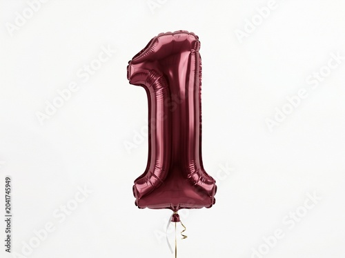 Floating metallic burgundy red foil balloon with shiny reflective surface against white background
