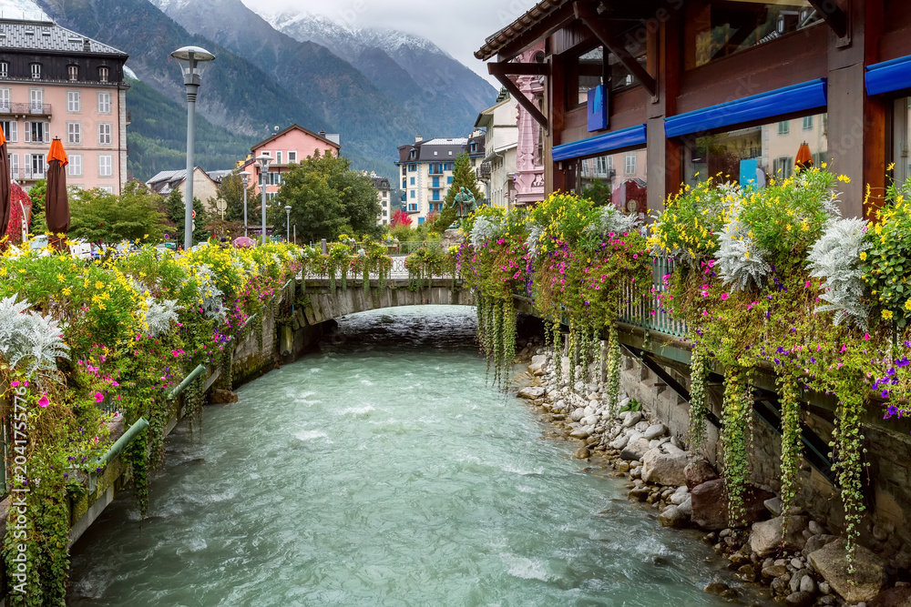 Fototapeta premium River and houses, flowers in center of Chamonix, France.