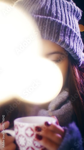 Young woman hold a cup of warm drink surrounded by Christmas spirit