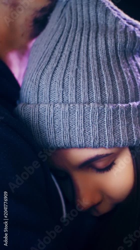 Beautiful young woman in warm hug with man leaning on chest for Christmas