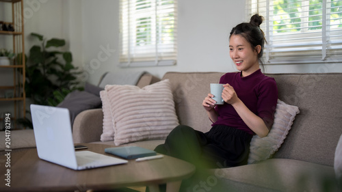 Konstfotografi young Asian women professional relaxing at home office with laptop computer drin