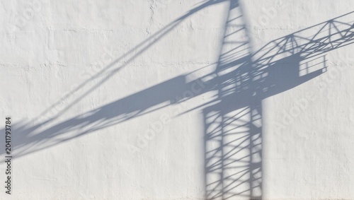 Graphic Shadow of a Construction Tower Crane Cast on a Blank Concrete Wall