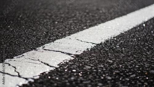 Close Up of a Textured White Painted Line on Wet Asphalt Road during Rain
