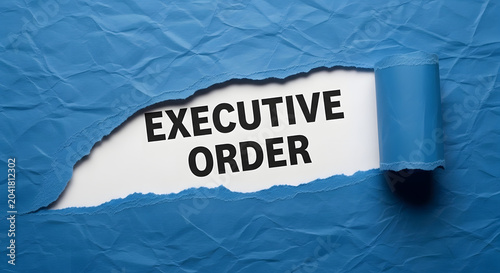 Torn blue paper reveals black text executive order on white background ripped