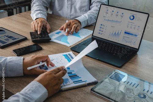 Business team reviewing accounting financial reports with calculator  charts  tablet  and dashboard on laptop during office meeting  supporting budget analysis  financial planning  and reporting workf