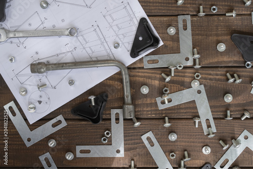 Metal shelving assembly process with bolts, nuts, brackets, tools and instruction manual. Suitable for furniture installation, home improvement and storage organization themes.