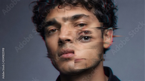 Young man with digital glitch effect on face. Distorted reality portrait with motion blur and chromatic aberration. Concept of identity loss, mental health, psychology and cyber technology