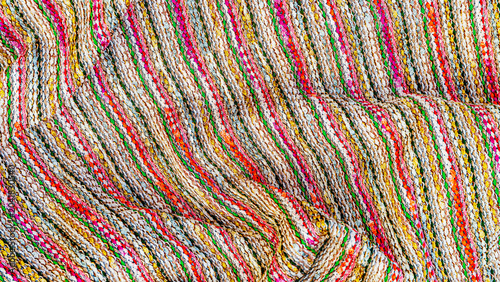 Schilderij op canvas Colorful woven fabric with bright patterns laid out on a flat surface in a texti