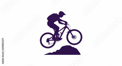Silhouette of a person on a mountain bike jumping over a dirt mound