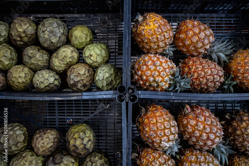 Row of Fresh Azorean Pineapples Displayed on Wooden Market Counter, Tropical Fruit Harvest from São Miguel Island