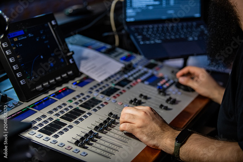 Foto Sound engineer man using mixing console for music production