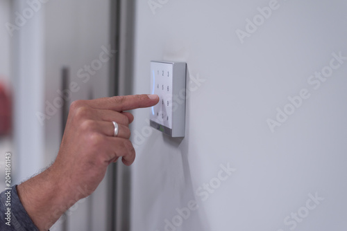 Obraz na płótnie Close-up of Hand Entering PIN Code on Digital Security Keypad