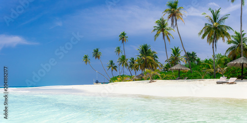 Vacation summer holidays leisure background - sunny tropical Caribbean paradise resort beach with white sand, lounger, palms on Maldive