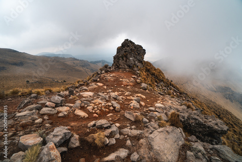 Rocky mountain trail on Popocatépetl volcano in Mexico with misty atmosphere and rugged terrain during daytime hiking adventure