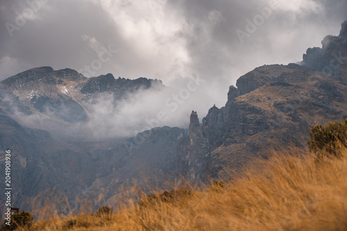 Dramatic view of Popocatépetl mountain with misty clouds and rugged terrain in Mexico during a cloudy day perfect for hiking and adventure