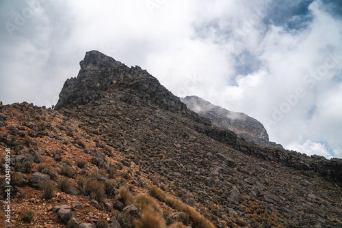 Rugged rocky landscape of Popocatépetl volcano in Mexico under cloudy sky ideal for hiking and trekking adventures