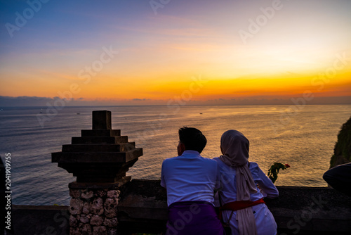 Obraz na płótnie Couple watching the sunset over the Indian Ocean at Uluwatu Temple