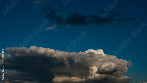 Dark gray rain clouds in the evening sky banner.