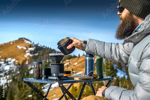 Foto Pour over coffee brewing in mountains with portable outdoor specialty coffee set