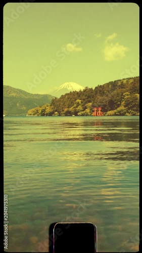 Lake view in Hakone, Japan with shrine Mount Fuji in background on beautiful sunny day, vintage retro 8mm film negative, vertical