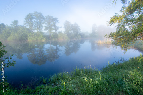 Canvas Print tranquil river landscape at dawn, with thick white fog hovering over the water