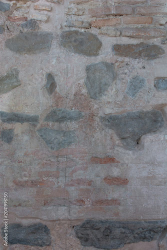 фотографія an ancient wall constructed from a mixture of rough grey stones and bricks