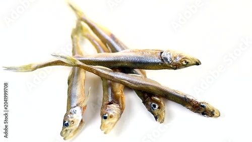 Smelt fish dried salted snack isolated on white background close up, Small fish heap of European smelt, Candlefish. Osmeridae, Osmerus eperlanus, Osmerus mordax close-up, top view, rotating