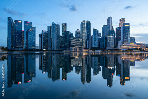 Modern City Skyline with Skyscraper Reflections on Calm Water at Dusk
