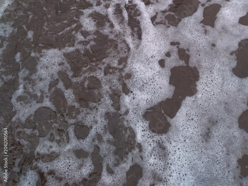 Sea Foam Waves on Wet Dark Sand Beach Texture